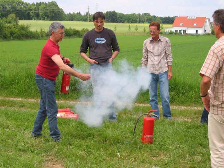 Rudolf Jäger demonstriert ein Feuerlöschgerät